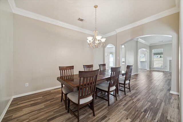 dining room with dark hardwood / wood-style floors, ornamental molding, and a chandelier