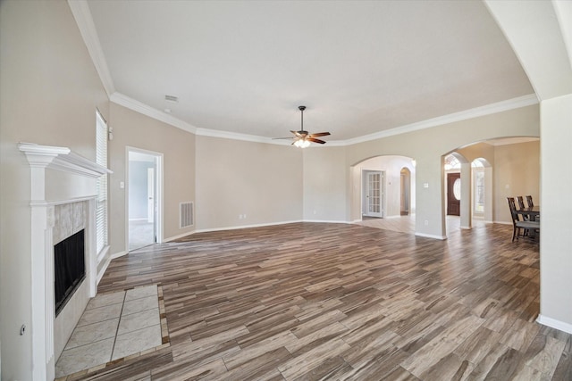 unfurnished living room with light wood-type flooring, ornamental molding, and a fireplace