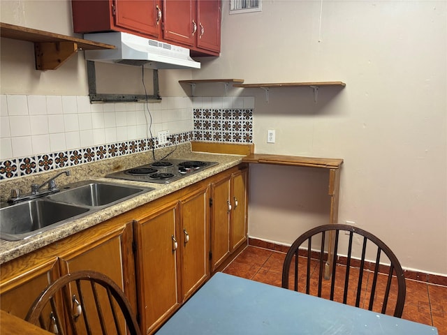 1612 Houston Blvd Unit 16, South Houston, TX 77587 - kitchen with stainless steel electric stovetop, under cabinet range hood, decorative backsplash, dark tile patterned flooring, and light countertops