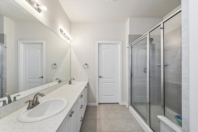 bathroom featuring tile patterned floors, a shower with shower door, and vanity