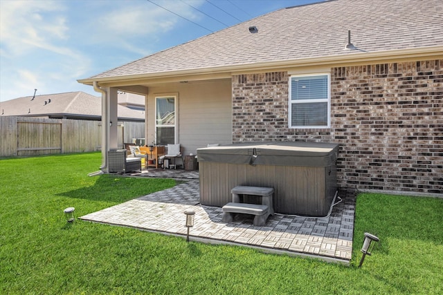 rear view of house with central AC, a lawn, a patio area, and a hot tub