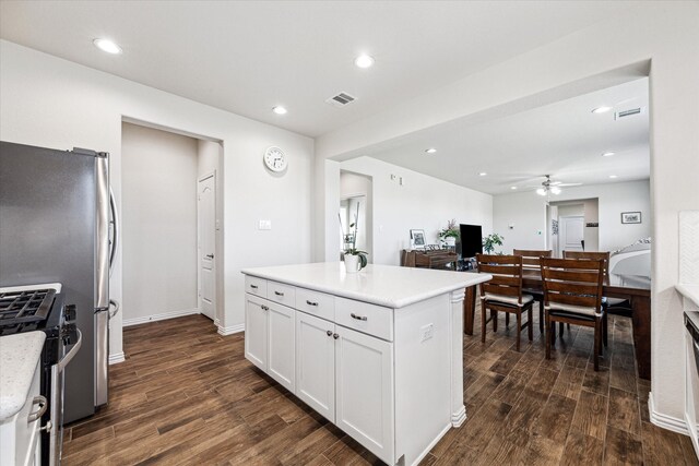 kitchen with ceiling fan, white cabinets, a kitchen island, dark hardwood / wood-style floors, and high end stainless steel range oven