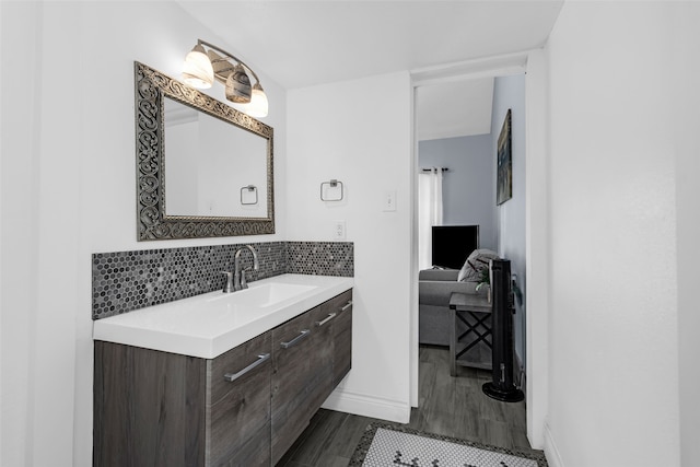 bathroom with tasteful backsplash, hardwood / wood-style floors, and vanity