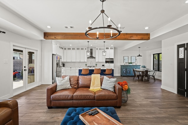 living room with a chandelier, french doors, beamed ceiling, and dark wood-type flooring