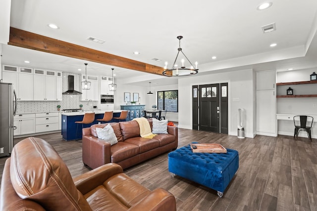 living room featuring beam ceiling, dark hardwood / wood-style flooring, and an inviting chandelier