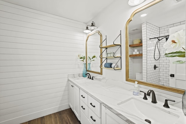 bathroom featuring a tile shower, vanity, and hardwood / wood-style flooring