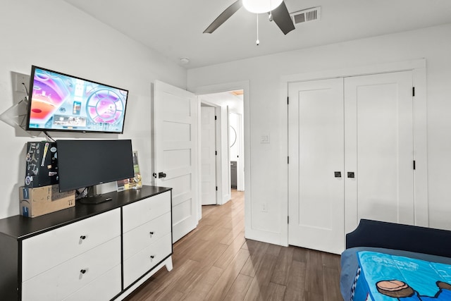 bedroom with ceiling fan, dark hardwood / wood-style floors, and a closet