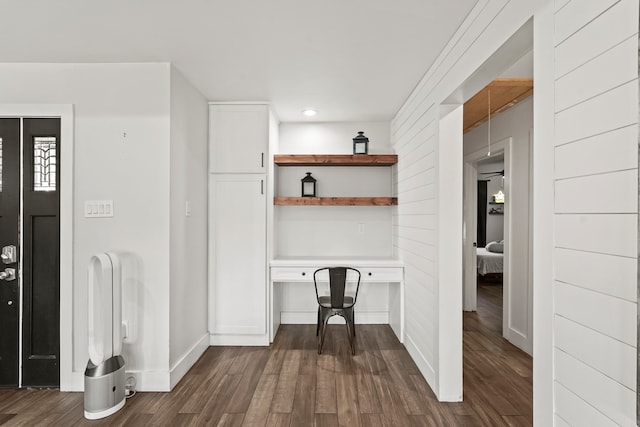 interior space featuring built in desk and dark wood-type flooring