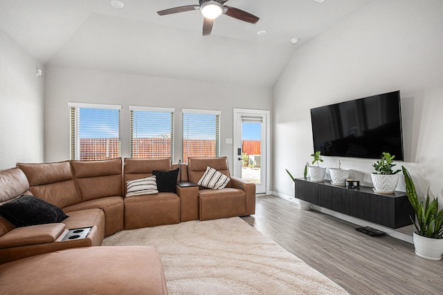 living room featuring light hardwood / wood-style floors, high vaulted ceiling, and ceiling fan