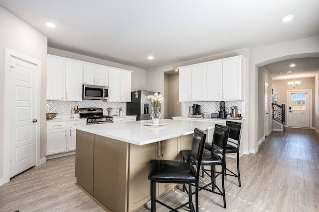 kitchen with white cabinets, appliances with stainless steel finishes, and a center island