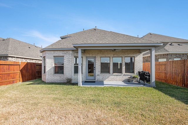 rear view of property with a patio, a yard, and ceiling fan