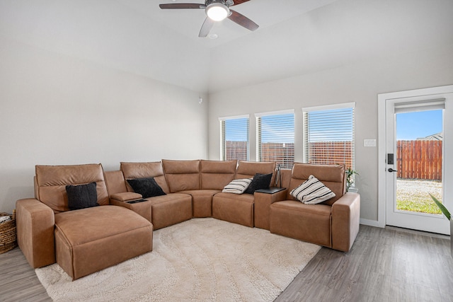 living room featuring ceiling fan, vaulted ceiling, and light hardwood / wood-style floors