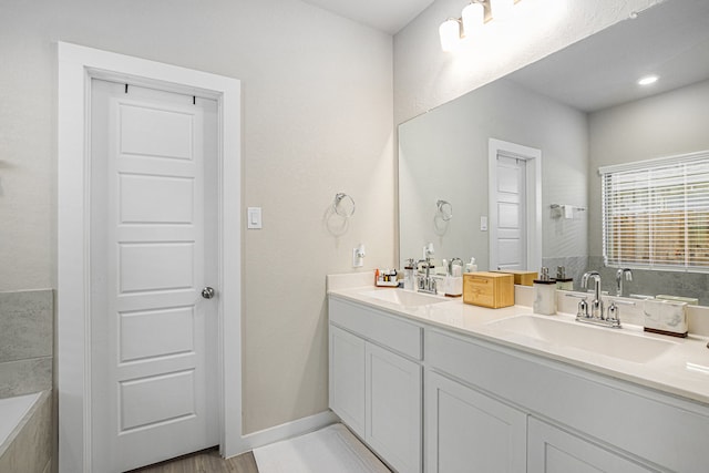 bathroom featuring wood-type flooring, vanity, and a bathtub