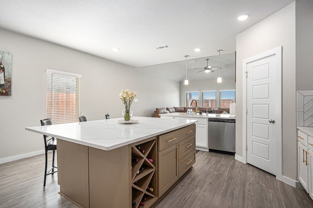 kitchen featuring a kitchen island, stainless steel dishwasher, wood-type flooring, a breakfast bar, and kitchen peninsula