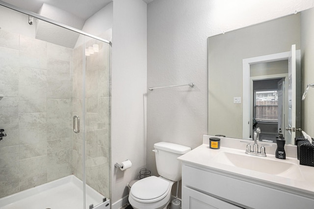 full bathroom featuring toilet, a stall shower, and vanity