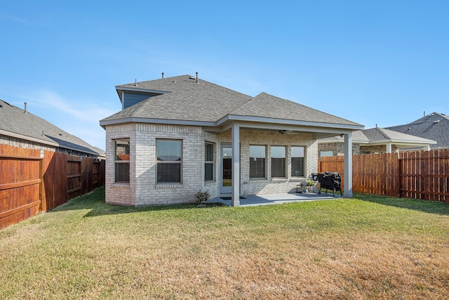 back of house with a patio and a lawn