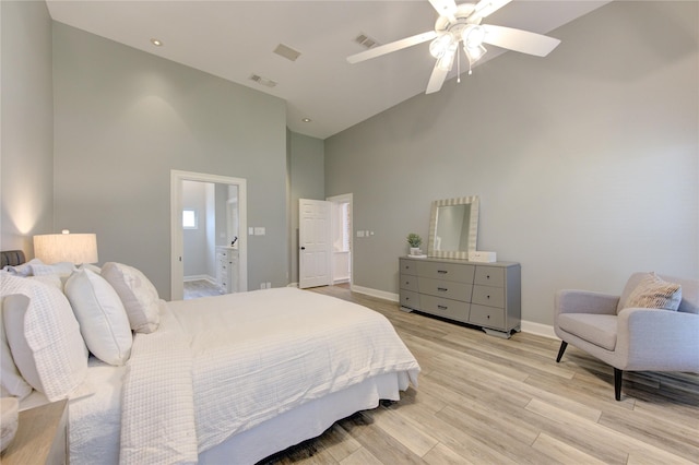 bedroom with ceiling fan, light hardwood / wood-style floors, ensuite bathroom, and high vaulted ceiling