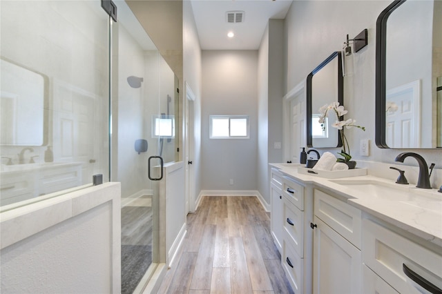 bathroom with hardwood / wood-style floors, vanity, and walk in shower