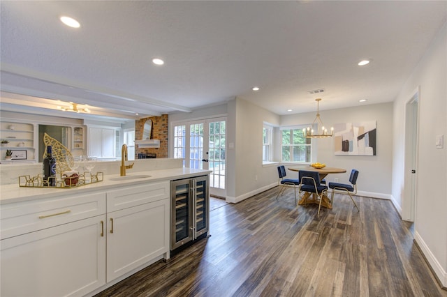 kitchen with french doors, beverage cooler, sink, white cabinets, and dark hardwood / wood-style floors