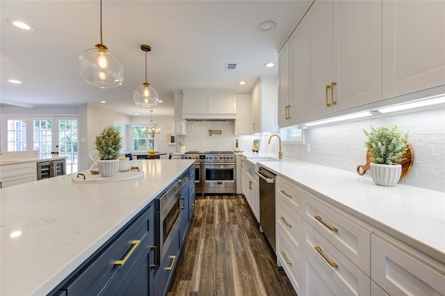 kitchen with dark hardwood / wood-style flooring, white cabinetry, sink, and stainless steel appliances