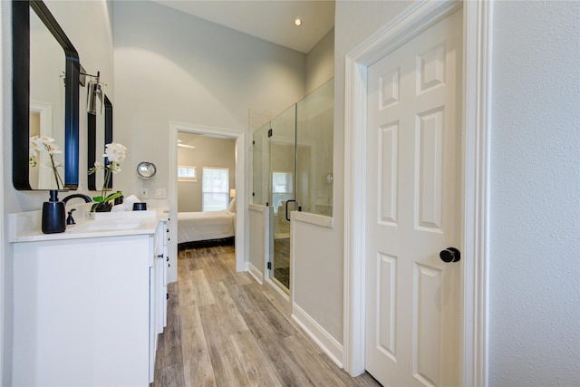 bathroom with hardwood / wood-style flooring, vanity, and a shower with shower door