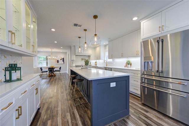 kitchen with dark wood-type flooring, a center island, white cabinets, and stainless steel appliances