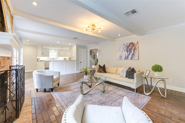 living room featuring a chandelier, a brick fireplace, and beamed ceiling