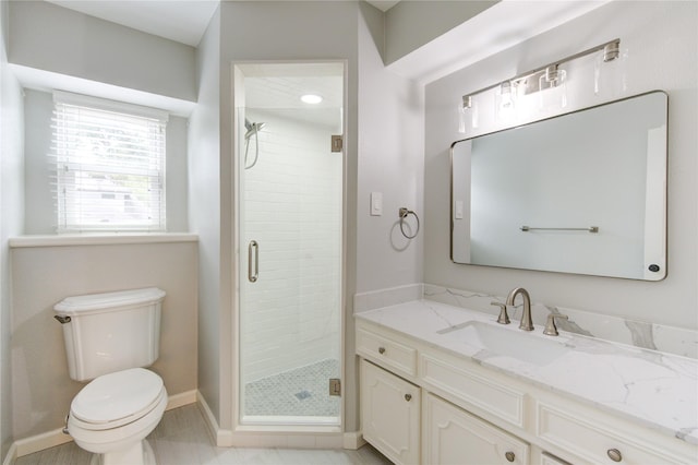 bathroom featuring tile patterned flooring, vanity, a shower with shower door, and toilet