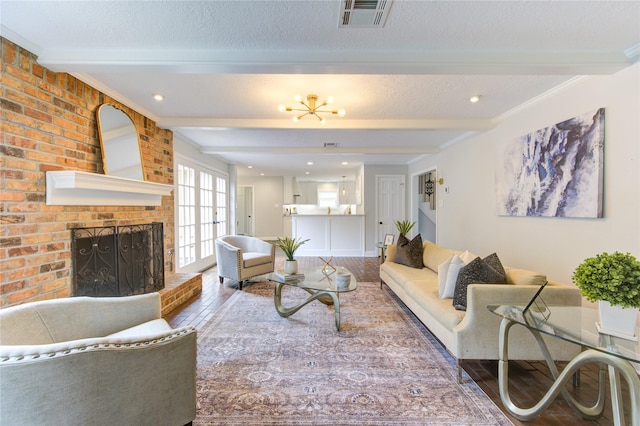 living room featuring beamed ceiling, hardwood / wood-style floors, a textured ceiling, and a fireplace