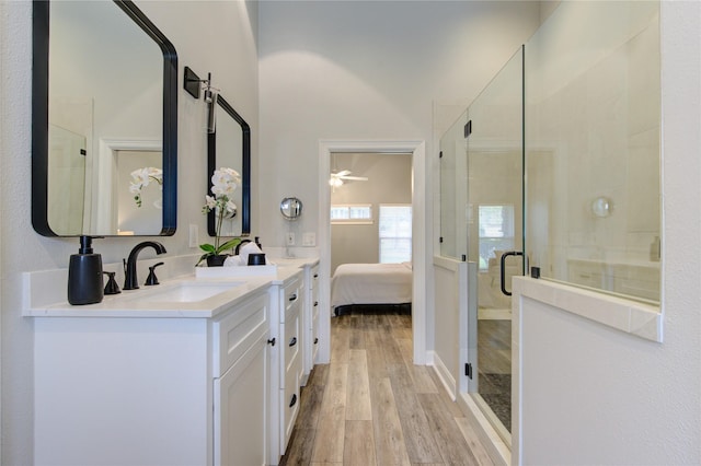 bathroom featuring hardwood / wood-style floors, vanity, an enclosed shower, and ceiling fan