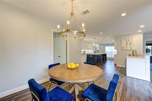 dining room with dark hardwood / wood-style flooring and a notable chandelier