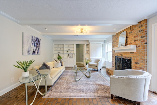 living room with beamed ceiling, a textured ceiling, a brick fireplace, and ornamental molding