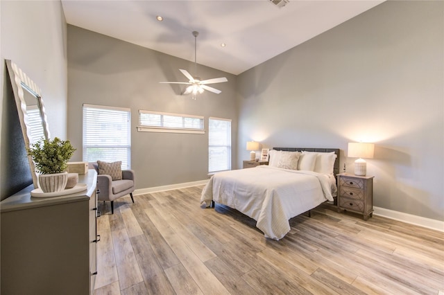 bedroom with light wood-type flooring, high vaulted ceiling, and ceiling fan