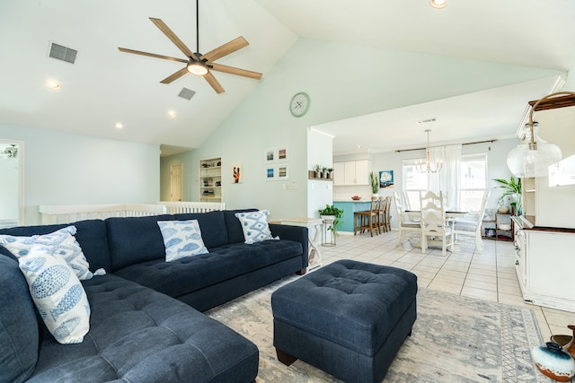 tiled living room featuring ceiling fan with notable chandelier and high vaulted ceiling