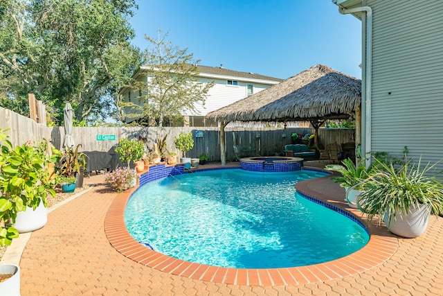 view of pool featuring pool water feature, a gazebo, an in ground hot tub, and a patio area