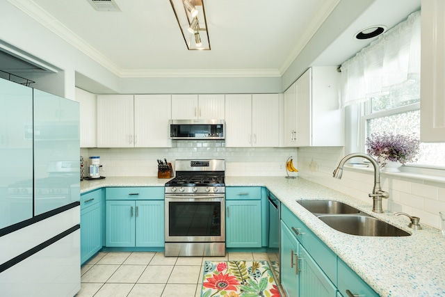 kitchen featuring tasteful backsplash, sink, ornamental molding, white cabinetry, and appliances with stainless steel finishes