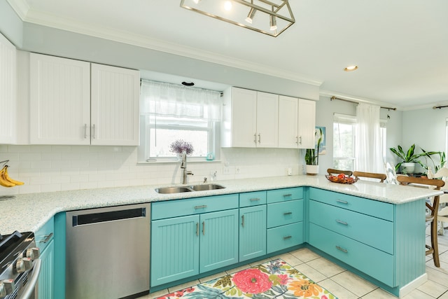 kitchen with kitchen peninsula, a healthy amount of sunlight, appliances with stainless steel finishes, and white cabinetry