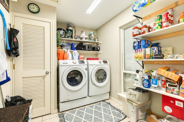 laundry area featuring washing machine and dryer and light tile patterned floors