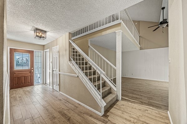 foyer entrance featuring ceiling fan, a textured ceiling, and hardwood / wood-style floors