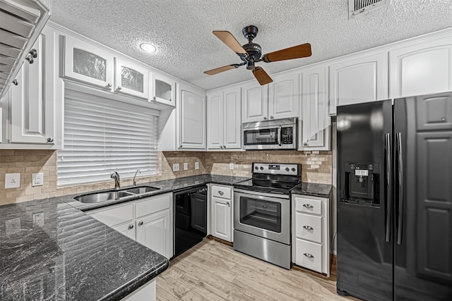 kitchen with white cabinets, sink, decorative backsplash, and black appliances