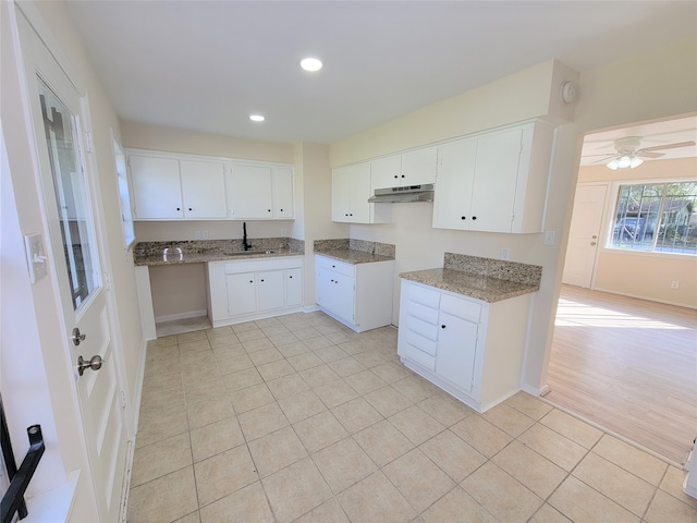 kitchen featuring light stone counters, ceiling fan, white cabinets, sink, and light hardwood / wood-style floors