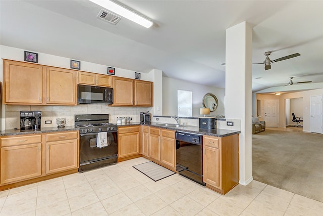 kitchen featuring ceiling fan, dark stone counters, sink, black appliances, and light tile patterned floors