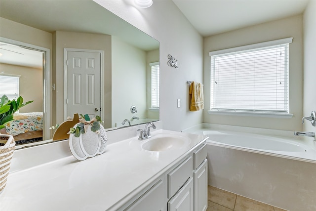 bathroom with tile patterned floors, a tub, and vanity