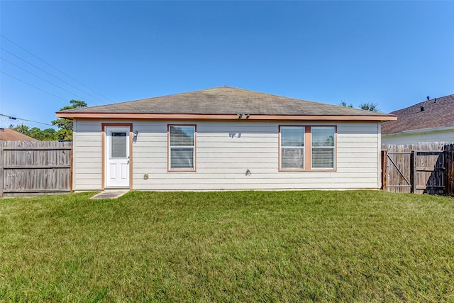 rear view of property featuring a lawn