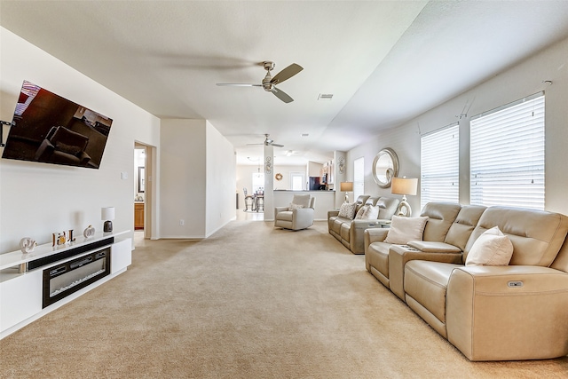 living room with ceiling fan and light colored carpet