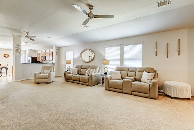 carpeted living room with ceiling fan