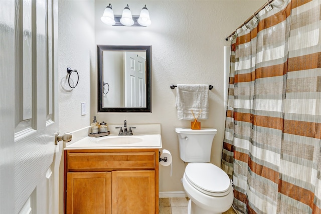 bathroom with vanity, tile patterned flooring, toilet, and walk in shower