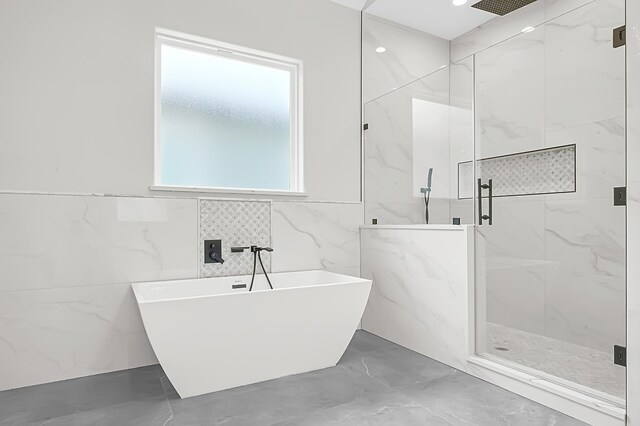 bathroom featuring separate shower and tub and tile walls