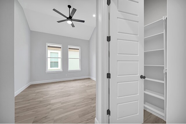 spare room with ceiling fan, vaulted ceiling, and light hardwood / wood-style floors