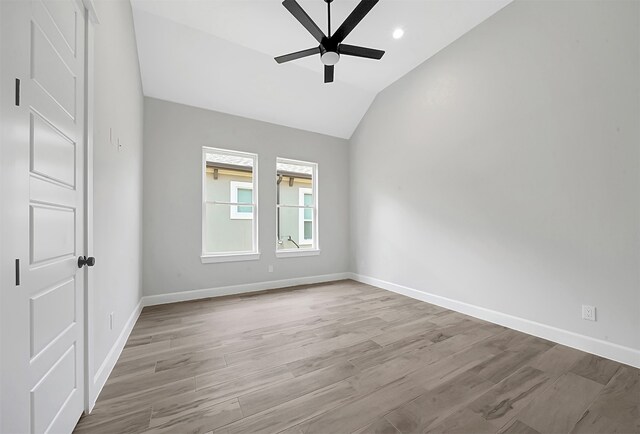 empty room featuring ceiling fan, light hardwood / wood-style floors, and vaulted ceiling